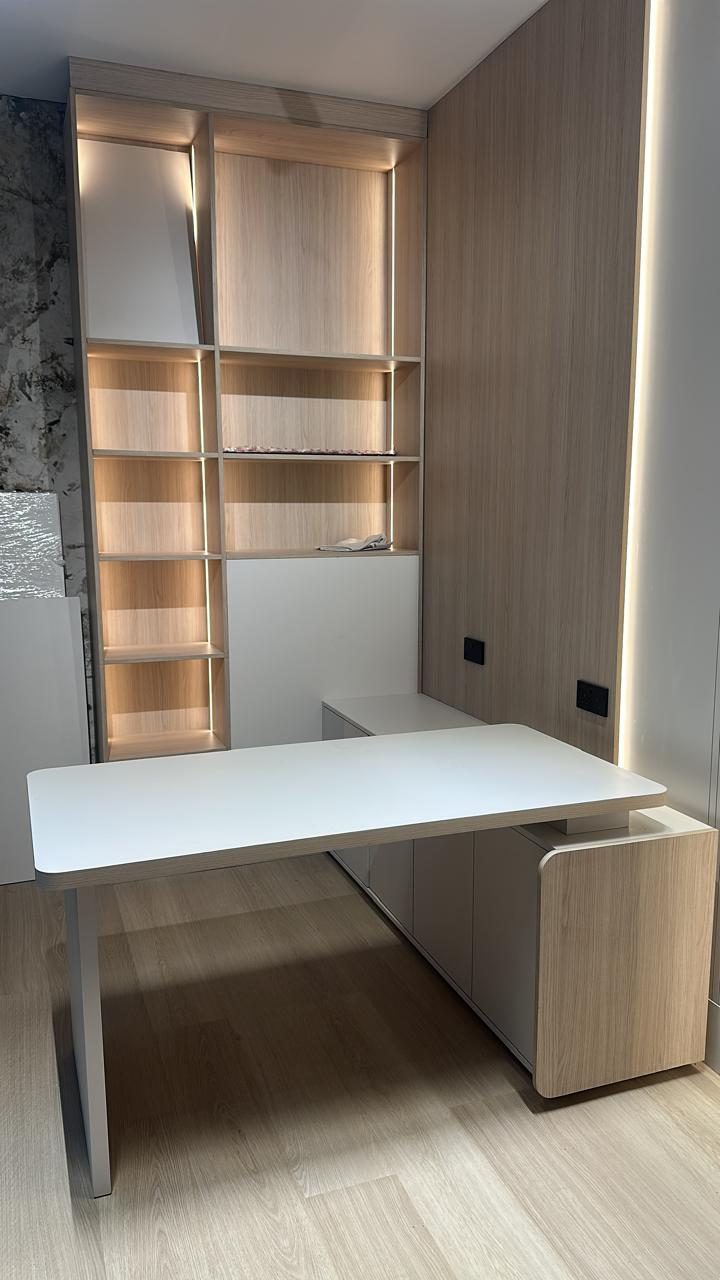 Oak veneer study wall with lit open shelving and a built-in white desk